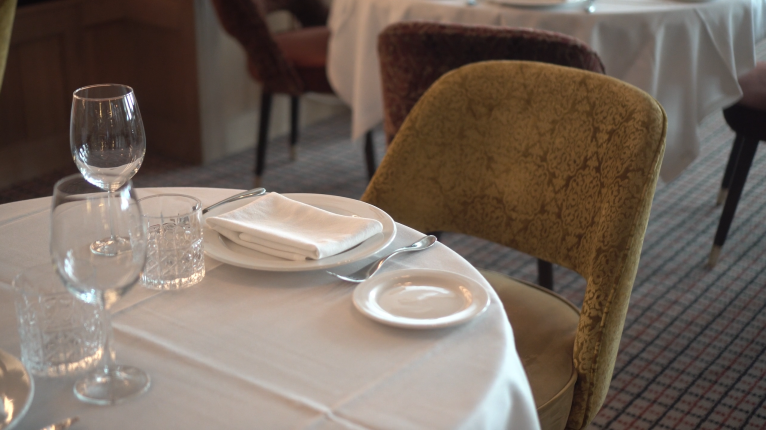 Elegantno postavljen restoranski sto sa belim stolnjakom i salvetom